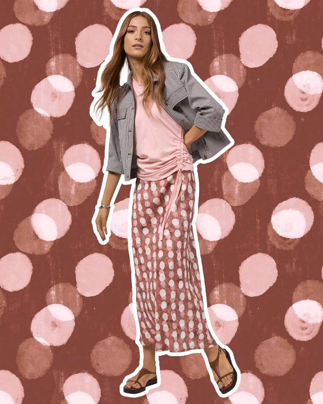 Madly Sweetly model in a pink midi skirt with allover white dot print and elastic gathered waist. On a studio background