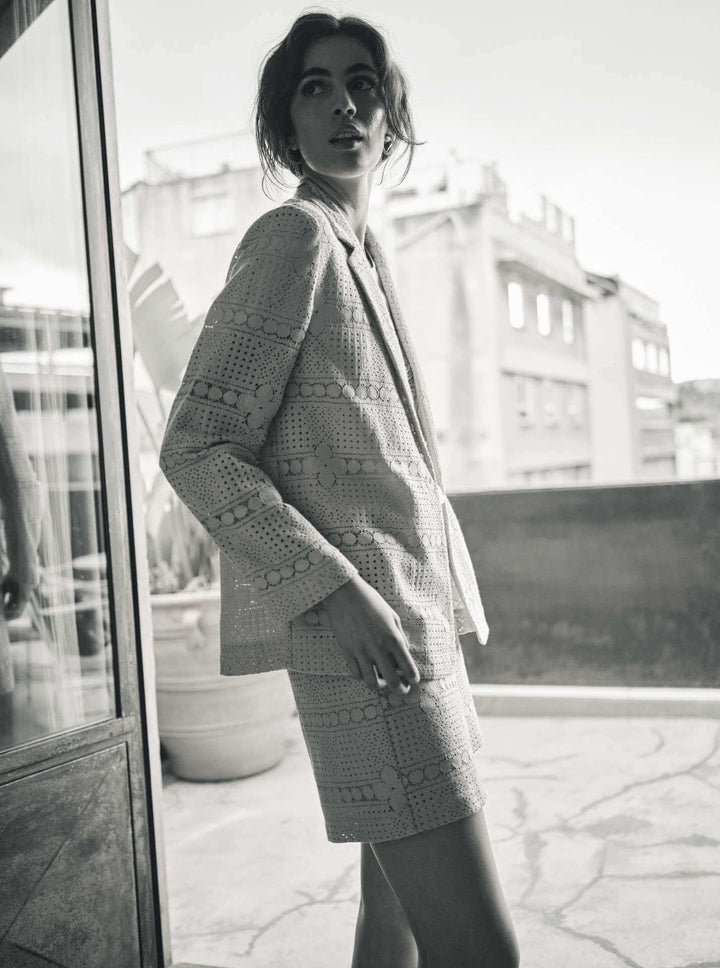 Woman wearing a short set with a white shirt featuring a circular design in a black &amp; white background. Ellinor shorts by Mos Mosh at The Wardrobe