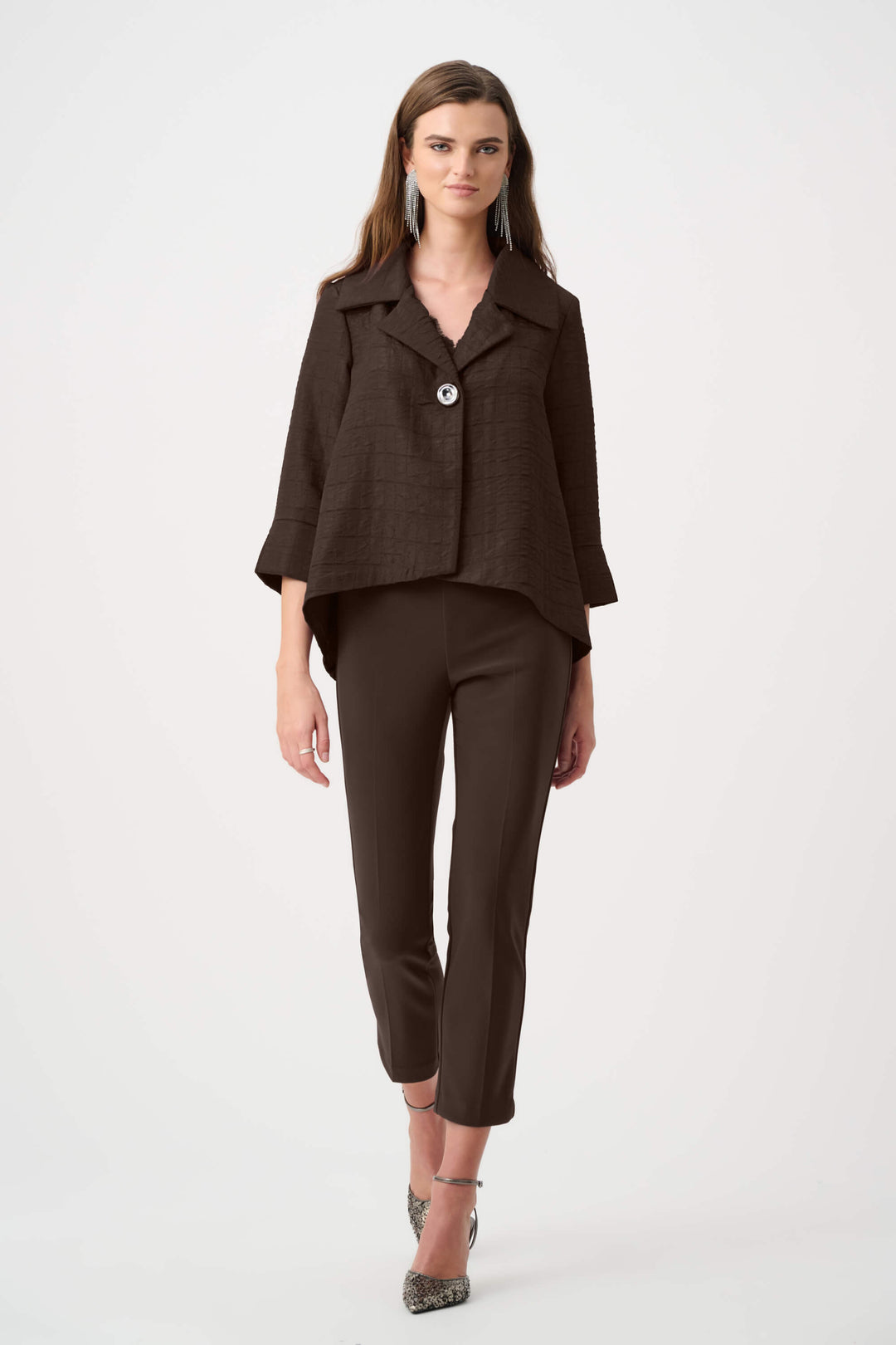 Joseph Ribkoff model wearing high-waisted, straight-leg cropped trousers in a deep brown color, paired with black pointed-toe heels, shown against a plain white studio background.