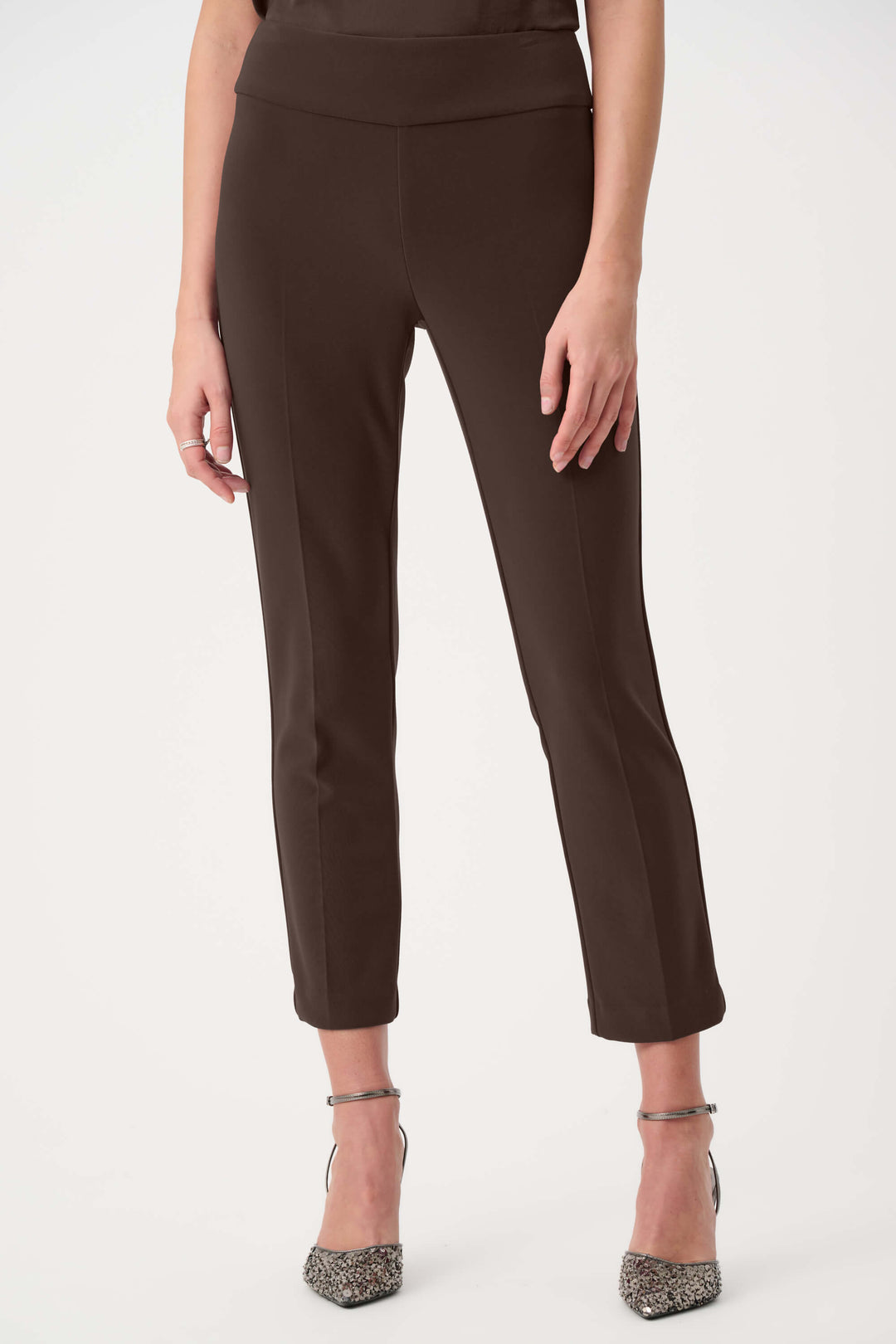 Joseph Ribkoff model wearing high-waisted, straight-leg cropped trousers in a deep brown color, paired with black pointed-toe heels, shown against a plain white studio background.