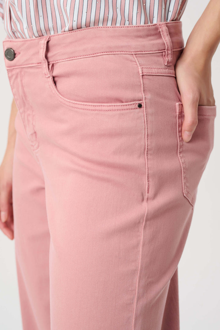 Joseph Ribkoff Close-up of a model wearing dusty pink high-waisted jeans, showing the front pocket, waistband, and hand in the side pocket against a plain light background.
