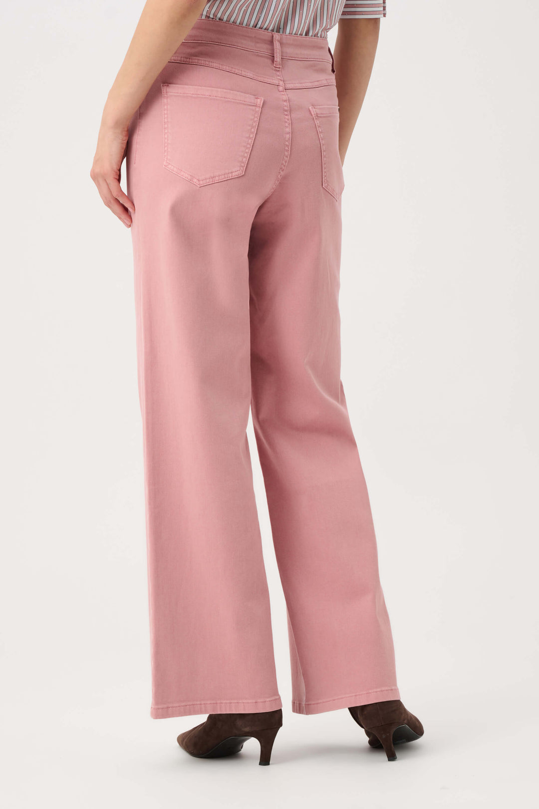 Joseph Ribkoff modeling a pink and white vertically striped button-down shirt with puffed sleeves, paired with dusty pink wide-leg pants and dark brown pointed-toe heels, against a plain light gray studio background. Back view 