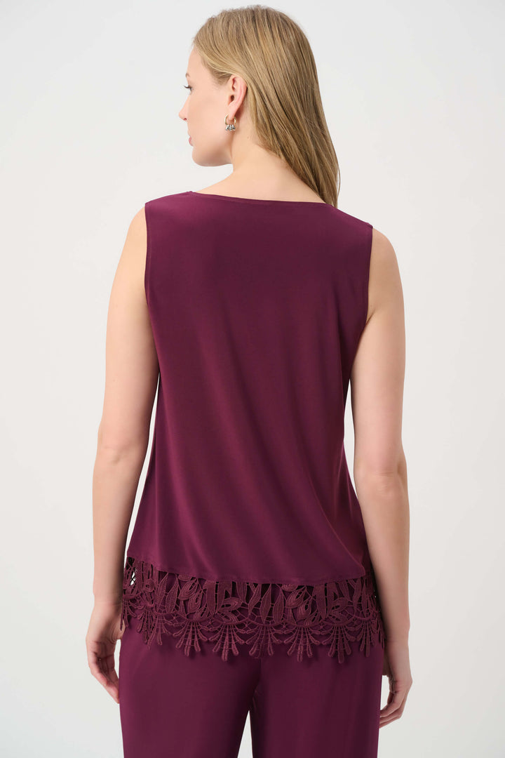 Joseph Ribkoff modeling a sleeveless scoop-neck top in deep burgundy with a matching lace-trimmed hem, paired with matching pants, against a plain light gray studio background. Back view 