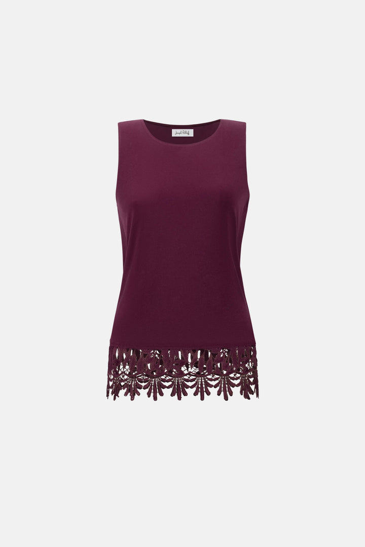 Joseph Ribkoff modeling a sleeveless scoop-neck top in deep burgundy with a matching lace-trimmed hem, paired with matching pants, against a plain light gray studio background. Flat Image 