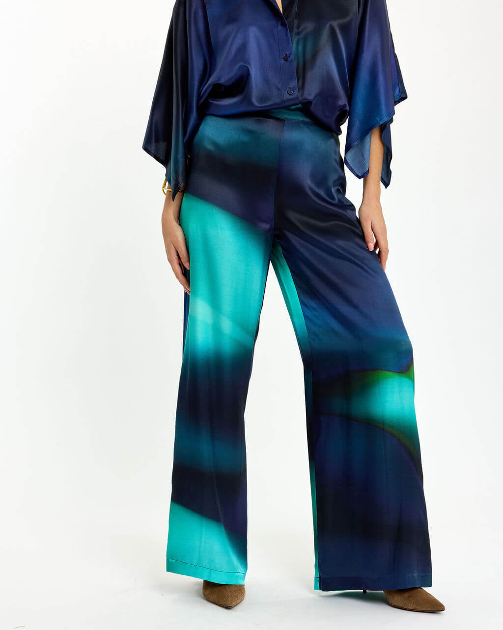 Blue and teal wide-leg trousers with draped satin sheen and abstract watercolor pattern