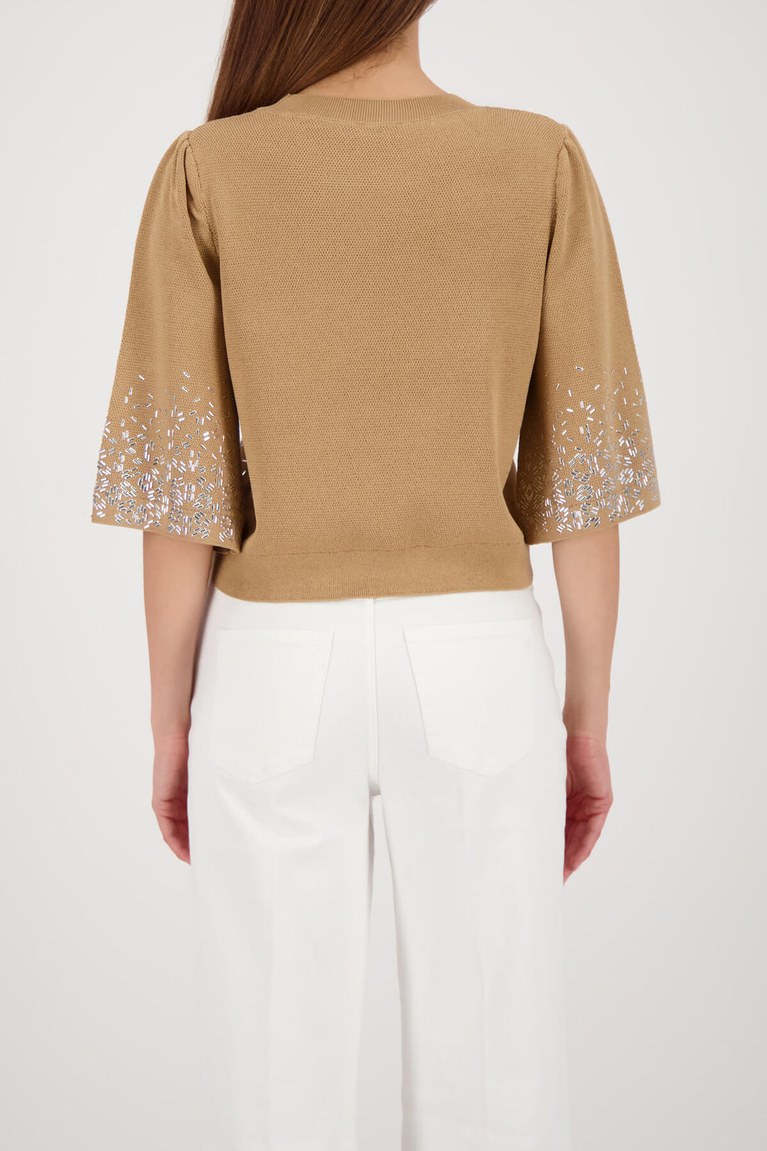 Beige knit top back view with solid knit back and jeweled speckle sleeve cuffs
