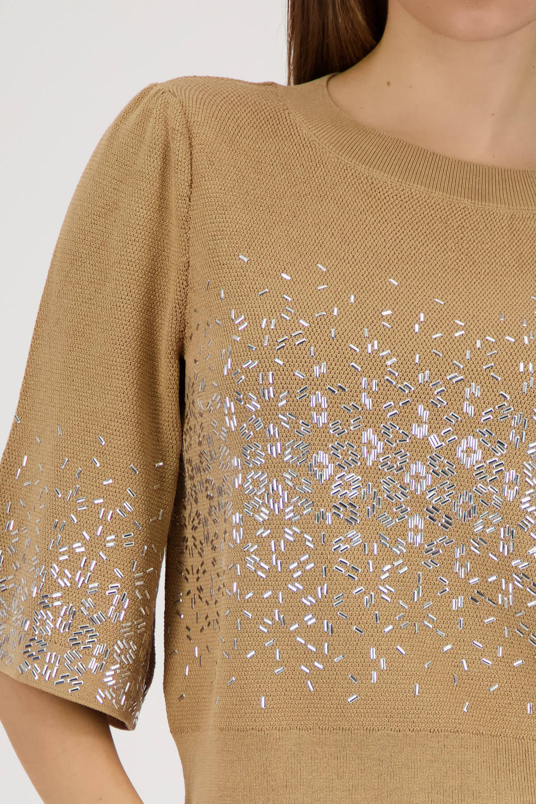 Beige knit top close-up: jeweled speckle print across front and 3/4 sleeve