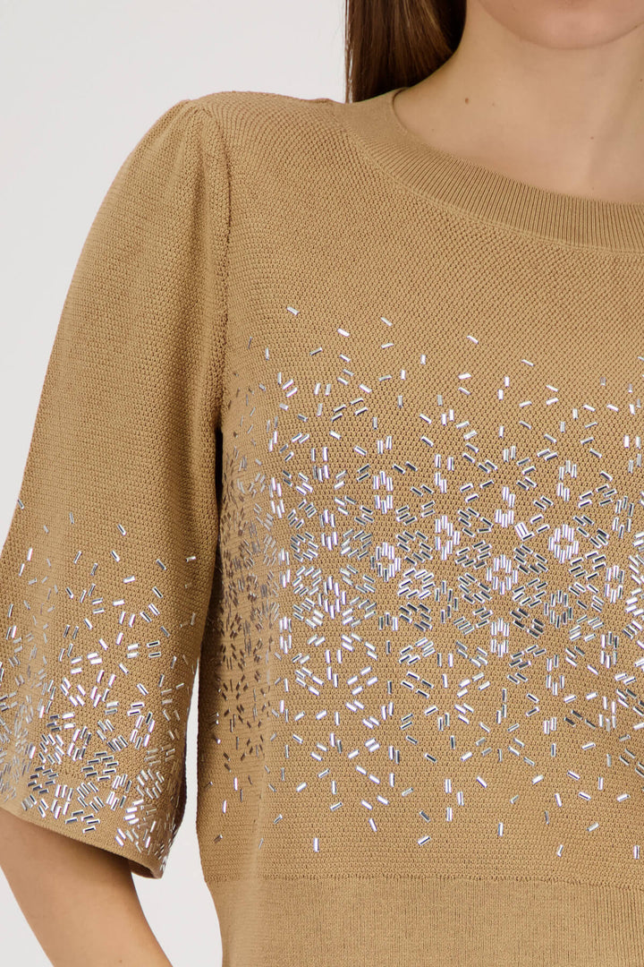 Beige knit top close-up: jeweled speckle print across front and 3/4 sleeve