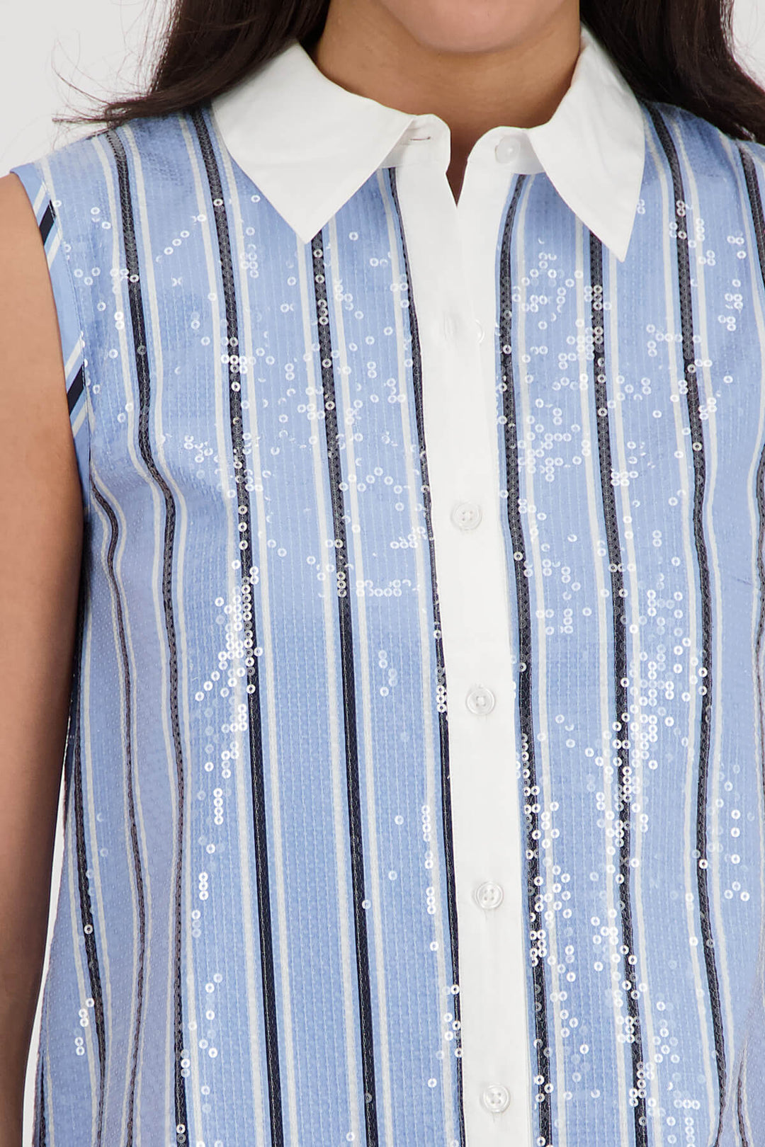 Monari woman modeling a sleeveless button-front top with vertical blue and white stripes, a white collar, and white pants against a light gray studio background. Close up 