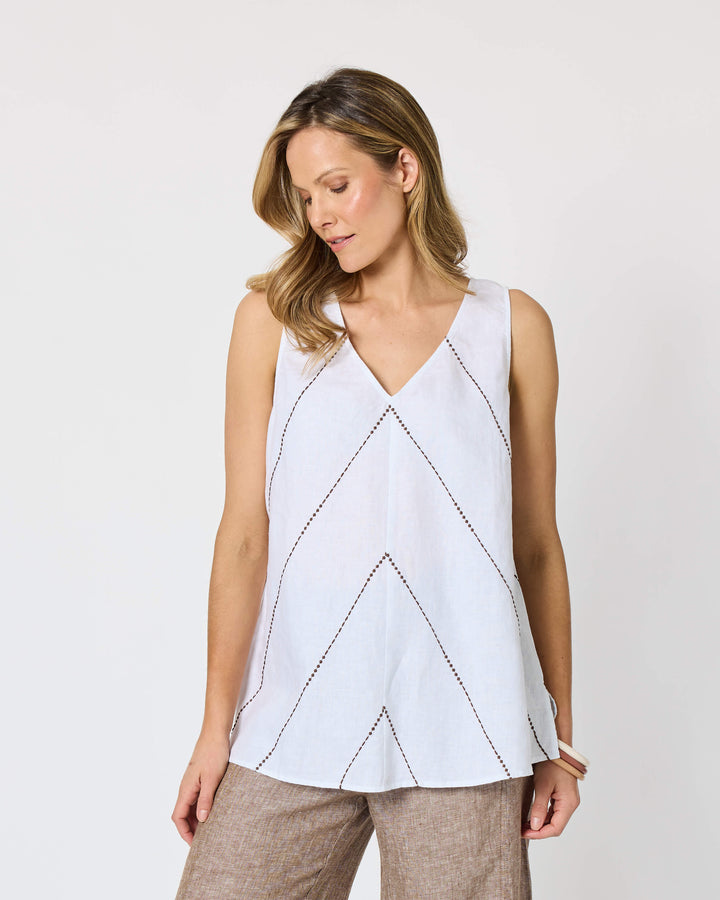 A Hammock &amp; Vine model wearing a sleeveless white top with thin brown line details and wide-leg taupe pants against a plain white studio background.