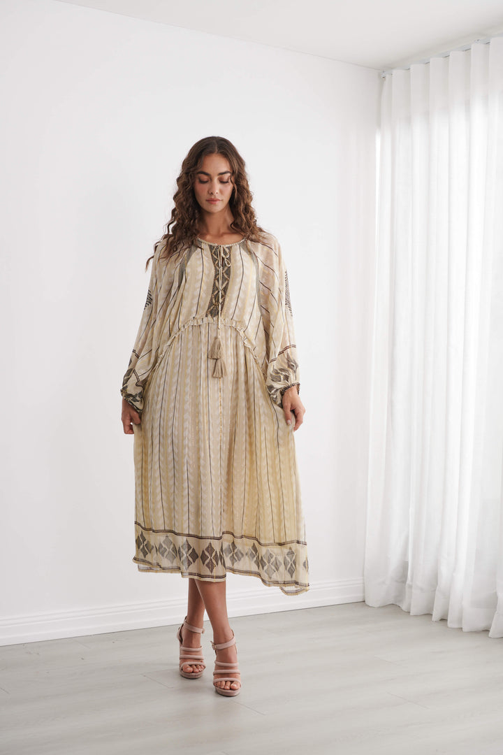 Cream Moroccan-style midi dress with vertical stripes, gold lurex trim, tassel ties