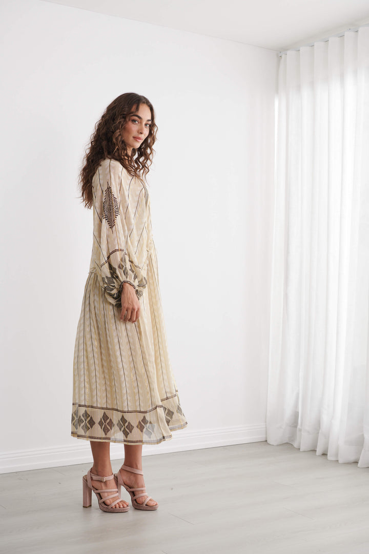 Beige/cream long-sleeve Moroccan stripe dress with border print and tassel accents