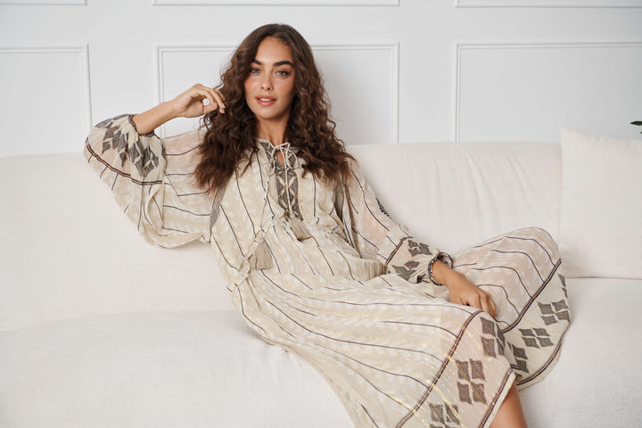 Cream dress close-up with braided neckline ties, lurex stripes, and diamond trim
