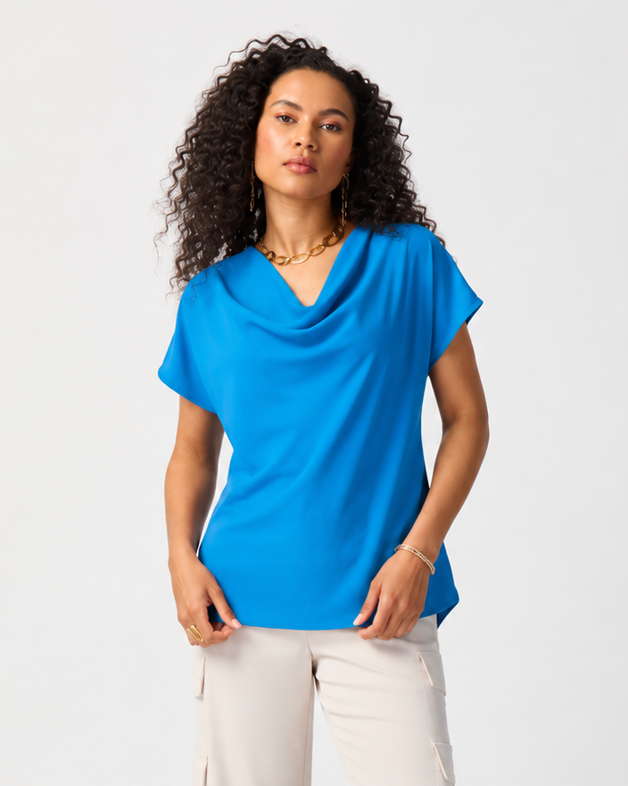 Woman wearing a blue top and white pants on a white background