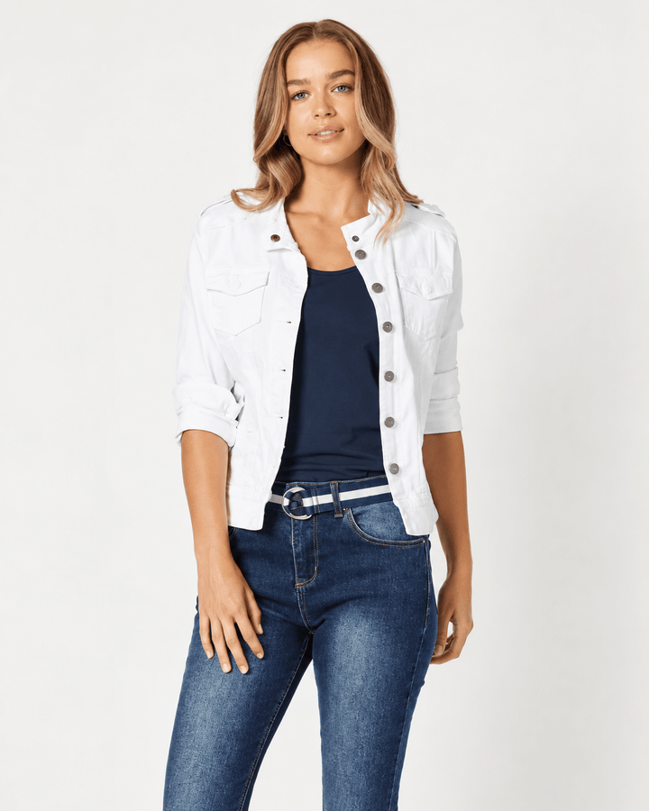 Threadz modeling a white cropped denim jacket over a navy blue top and dark blue jeans, standing against a plain light gray studio background.