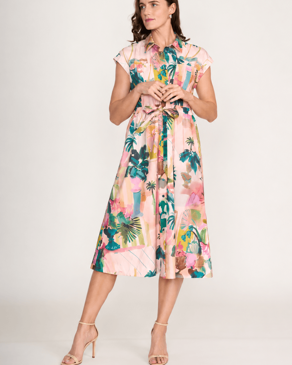 Foil clothing.A model on  a dress in Light pink,  cap-sleeve, midi length. A colourful botanical print and gathered waist. On a white background