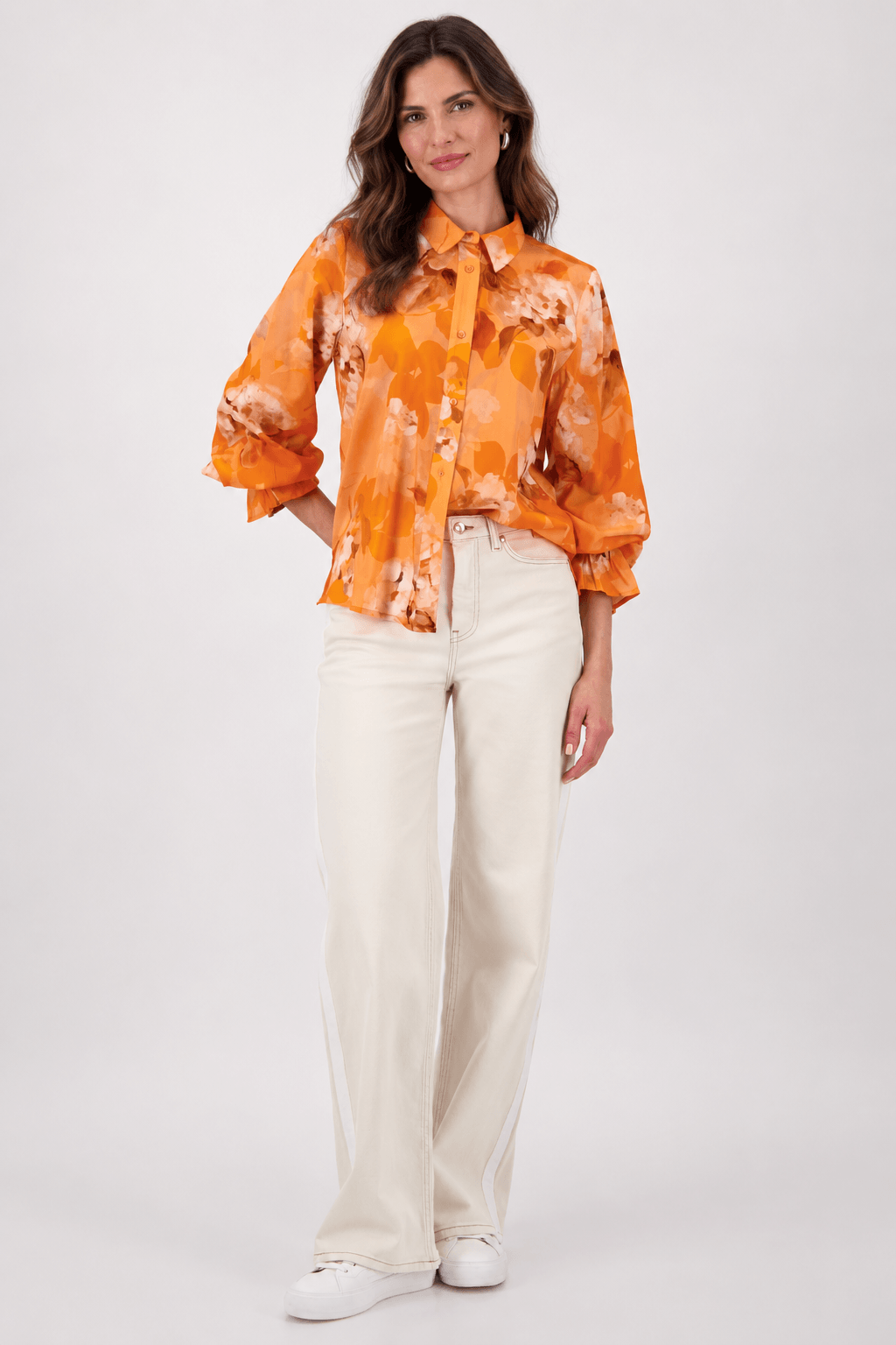 Monari orange tie-dye button-up blouse with pointed collar and long ruffle cuffs on a model. On white studio background.background