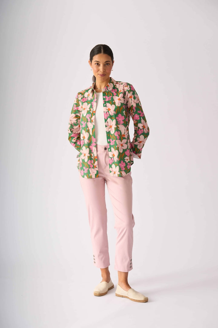 Foil model stands against a light gray studio background wearing a floral button-up shirt with pink and green tones, light pink pants, and beige slip-on shoes.