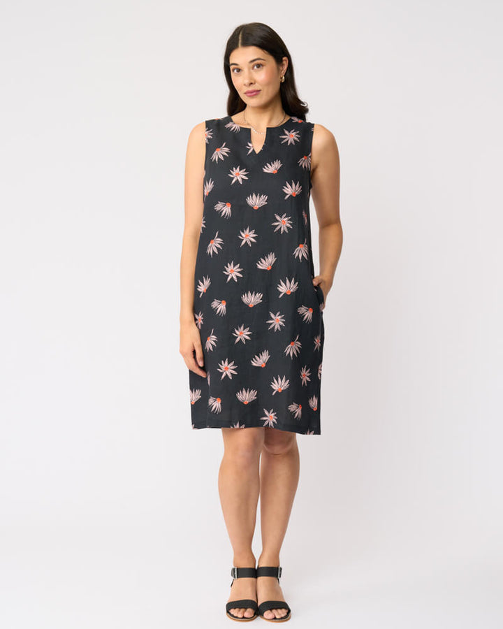 Foil clothing model in a sleeveless black knee-length dress with a pink and white floral pattern, standing against a plain white studio background.