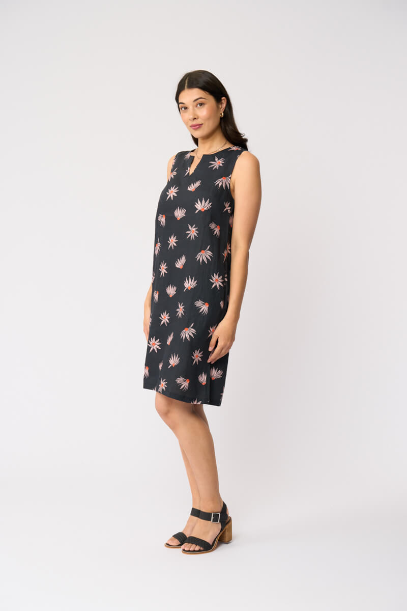 Foil clothing model in a sleeveless black knee-length dress with a pink and white floral pattern, standing against a plain white studio background.