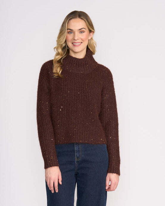Foil Model wearing a brown sweateryy and blue jeans on a white background