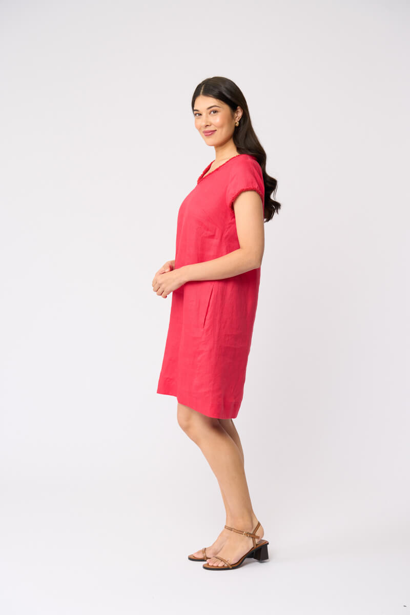 Foil clothing model in a short-sleeve V-neck linen dress in a vibrant pinkish-red color, standing against a plain white studio background.