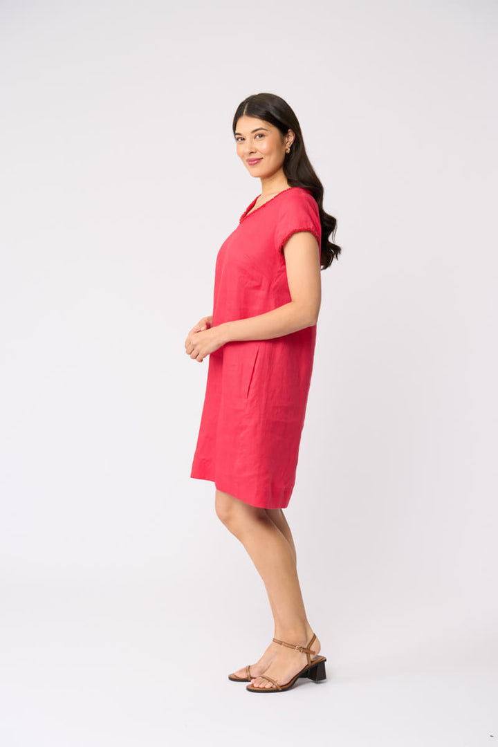 Foil clothing model in a short-sleeve V-neck linen dress in a vibrant pinkish-red color, standing against a plain white studio background.