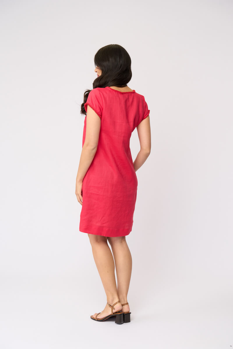 Foil clothing model in a short-sleeve V-neck linen dress in a vibrant pinkish-red color, standing against a plain white studio background. Back view