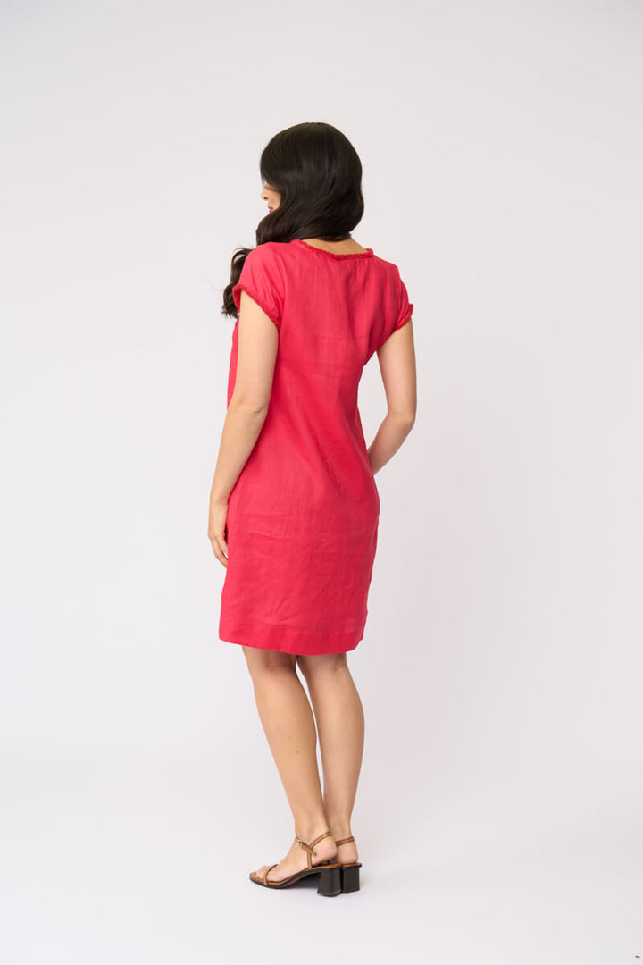 Foil clothing model in a short-sleeve V-neck linen dress in a vibrant pinkish-red color, standing against a plain white studio background. Back view