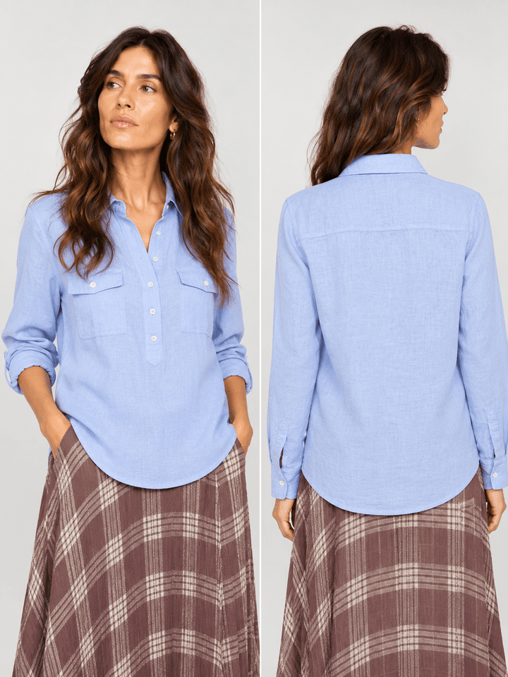 Mos Mosh woman wearing a light blue long-sleeve button-up shirt with two chest pockets and a brown plaid skirt, standing against a light gray studio background.