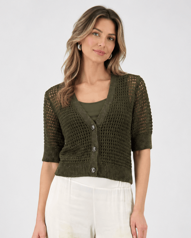 Monari woman modeling a short-sleeve olive green knit cardigan over a matching olive green top, paired with wide-leg white pants featuring a green and beige palm tree print, against a light gray studio background.