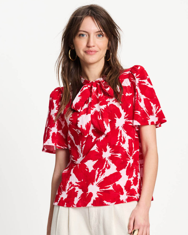 Pom Amsterdam Model  wearing a red floral blouse with white background