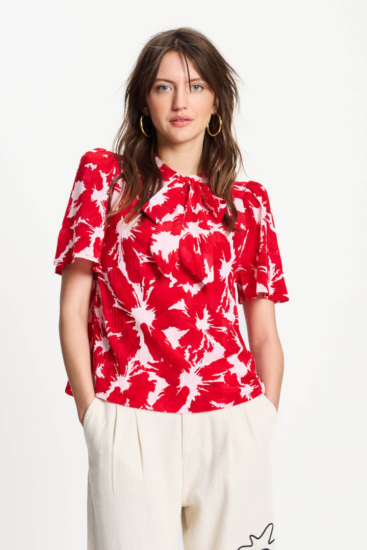 Red and white tie-dye crinkle bubble top with tied ruffled neckline, short sleeves