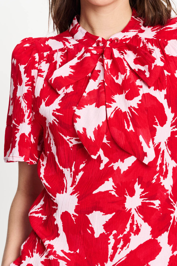 Red and white tie-dye crinkle bubble top with tied neck bow and ruffled collar