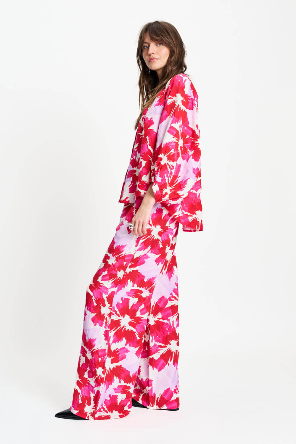 Side view: pink and red floral wide-leg pants with elastic waist, full length.
