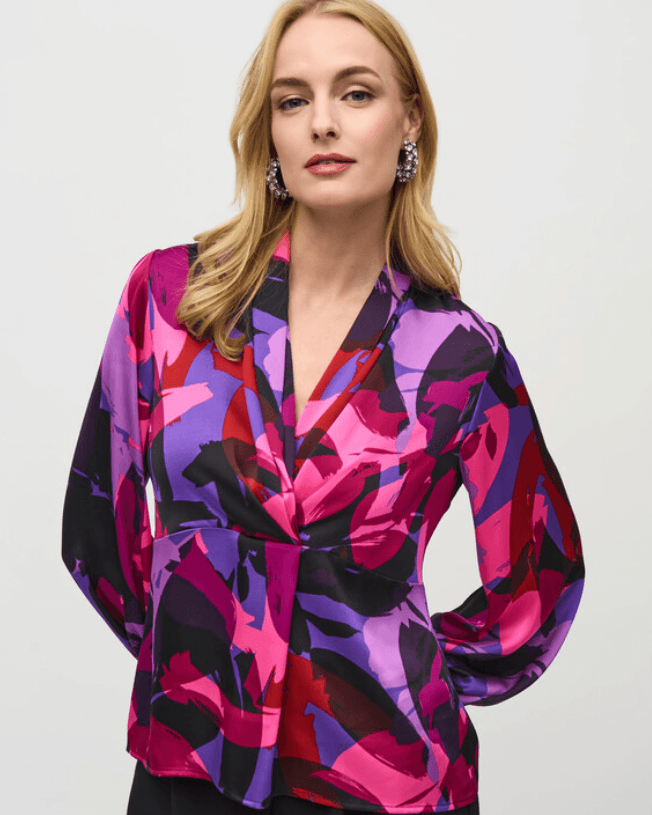 Woman wearing a colorful patterned blouse against a white background by Joseph Ribkoff at The Wardrobe 