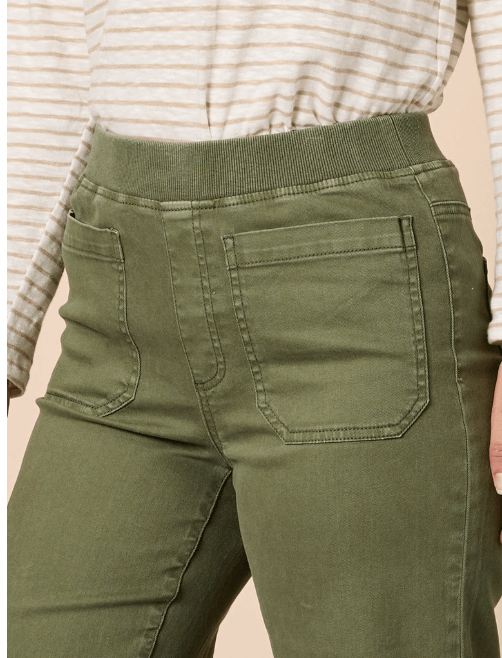 Threadz model close-up of a person wearing olive green high-waisted jeans with a ribbed waistband and back pockets, paired with a cream and beige striped long-sleeve top.