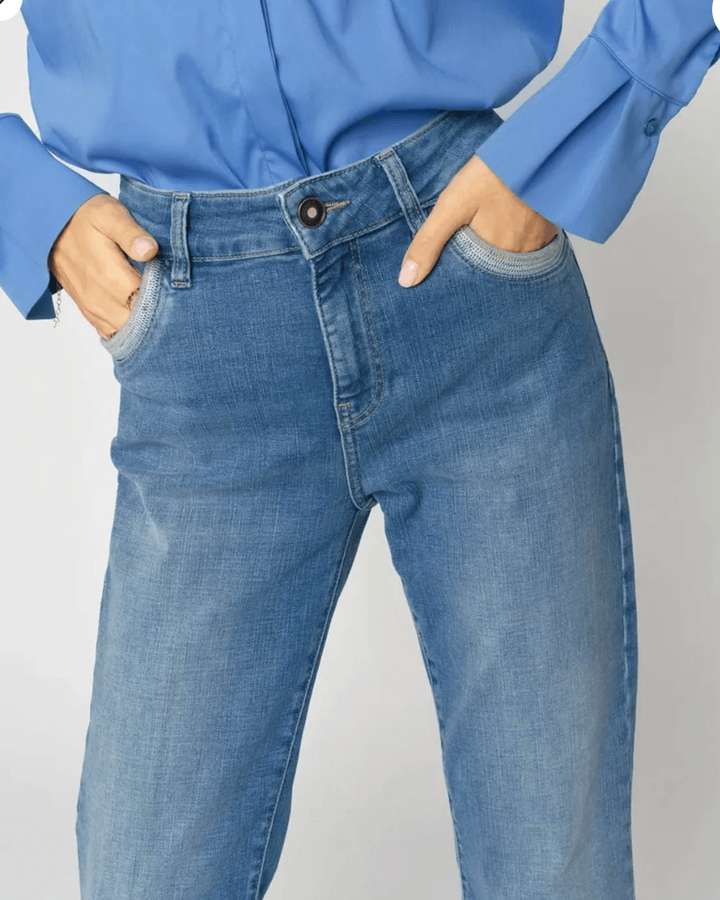 Mos Mosh model wearing medium-wash blue jeans with a blue long-sleeve button-up shirt, shown from the waist down against a light gray studio background.