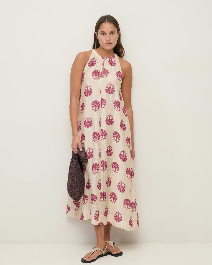 Yerse model in cream &amp; mauve maxi halter dress on a pale studio. background