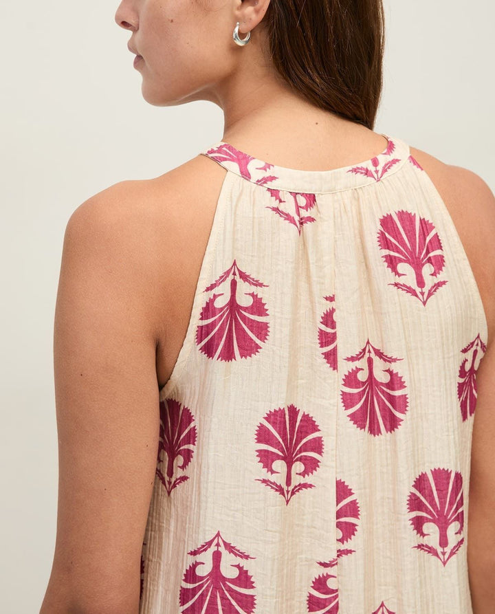 Yerse model in cream &amp; mauve maxi halter dress on a pale studio. background. Close up back view