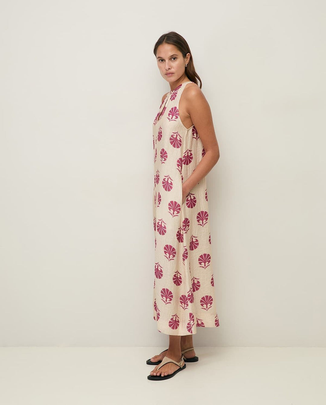Yerse model in cream &amp; mauve maxi halter dress on a pale studio. background