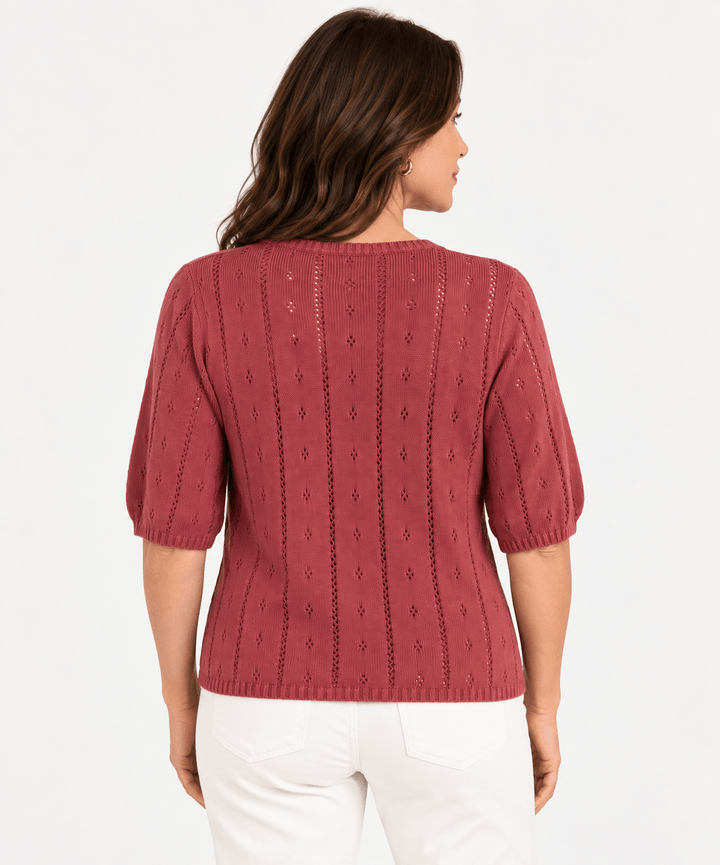 Yerse model in a short sleeve knit in dusky pink, on a white background. Back view 