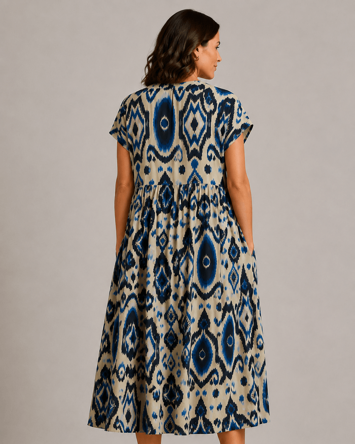 Blue-and-cream short-sleeve patterned dress, back view with tiered A-line hem