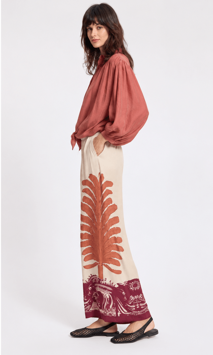 Cream 7/8 pants with rust-red and burgundy abstract border print, wide straight leg